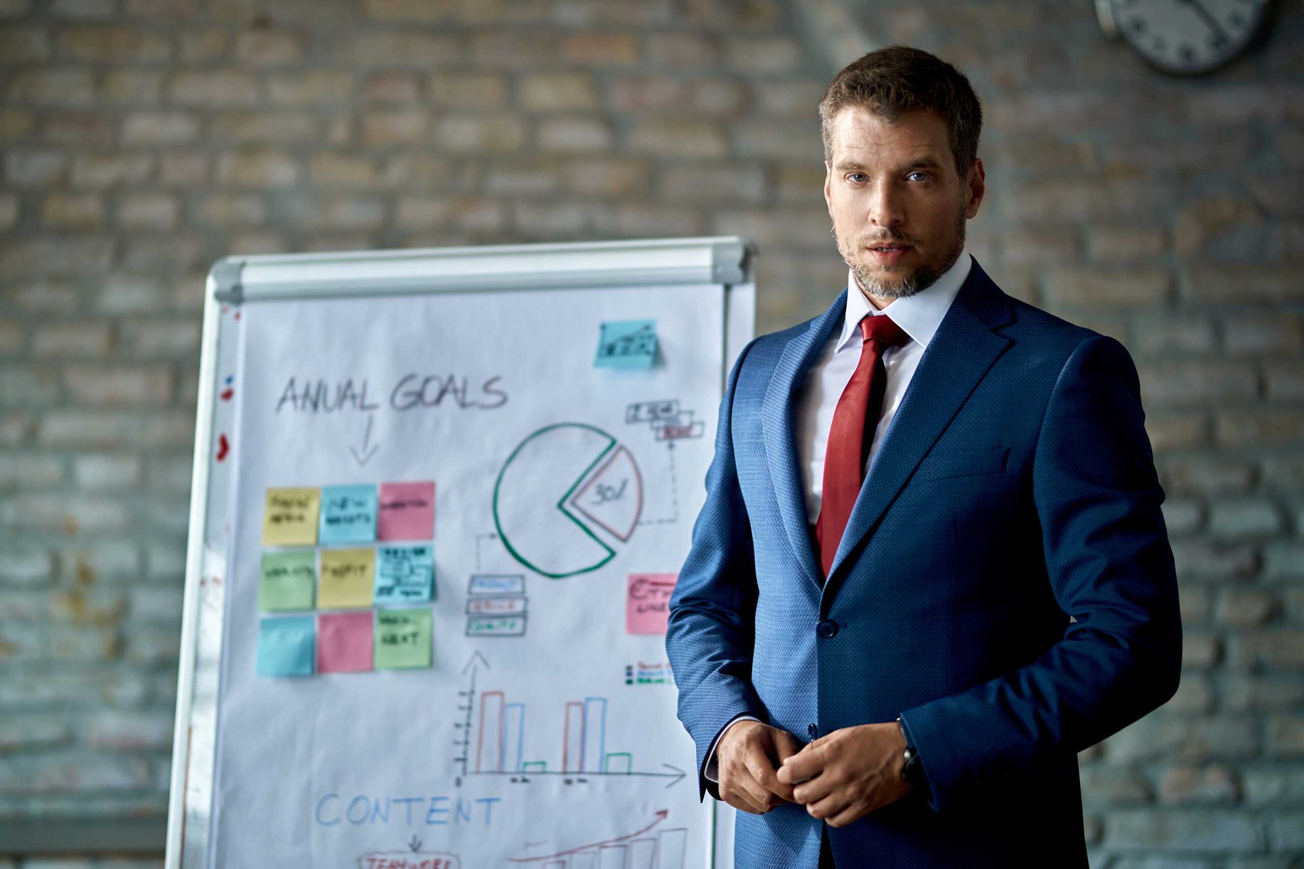 Businessman presenting charts and sales data on whiteboard